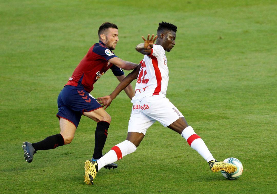 .PAMPLONA (NAVARRA), 19/07/2020.- El centrocampista ghanés del Mallorca, Iddrisu Baba (d), se lleva el balón ante el defensa de Osasuna, Oier Sanjurjo, durante el partido correspondiente a la última jornada de primera división que disputan esta noche en el estadio de El Sadar, en Pamplona. EFE/Villar López.