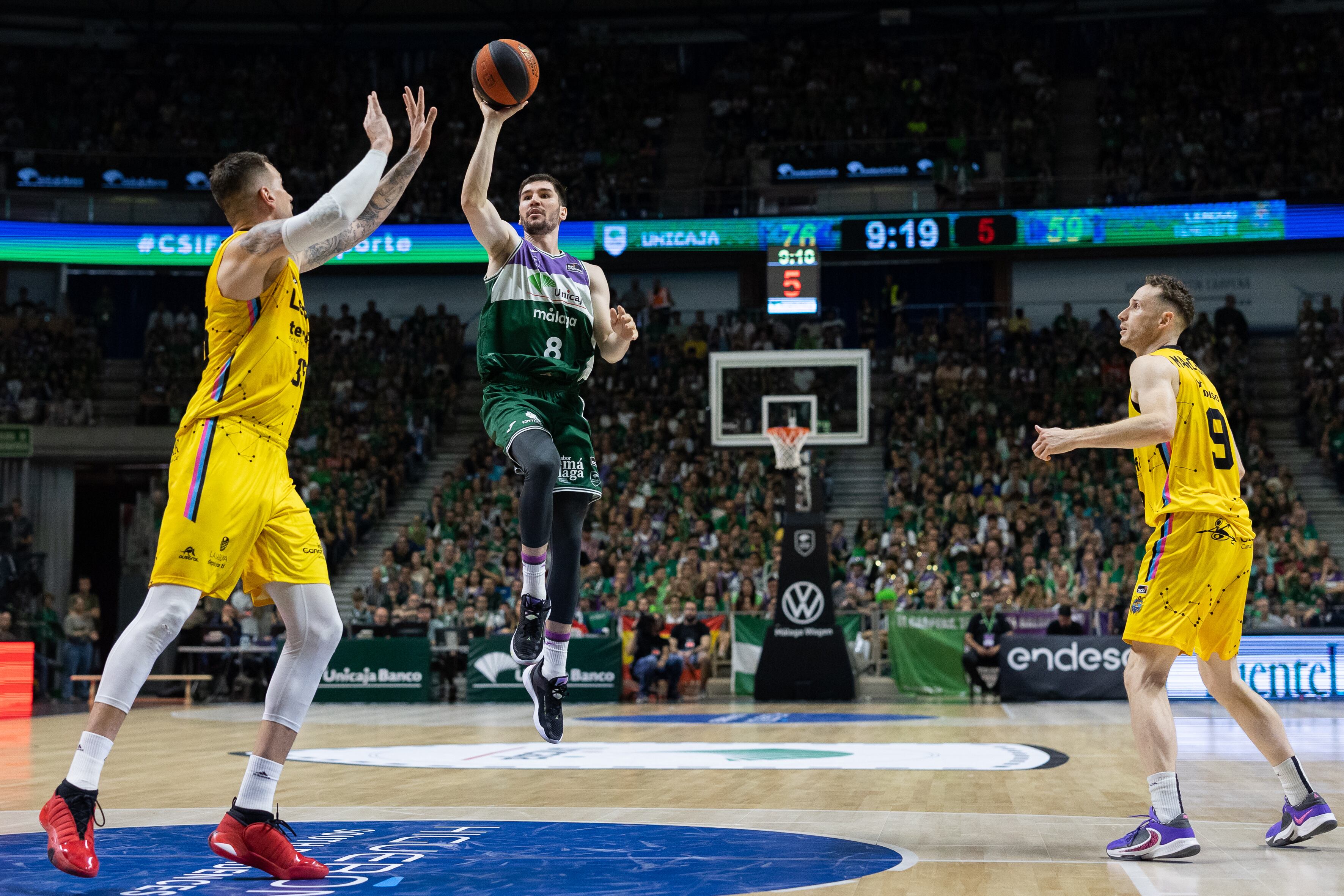 MÁLAGA (ESPAÑA), 01/06/2023.- El escolta del Unicaja Darío Brizuela (c) lanza a canasta ante el pívot del Lenovo Tenerife Fran Guerra (i), durante el segundo partido de la eliminatoria de cuartos de final por el titulo de la Liga Endesa disputado este jueves en el Palacio de los Deportes José María Martín Carpena de Málaga. EFE/ Carlos Díaz
