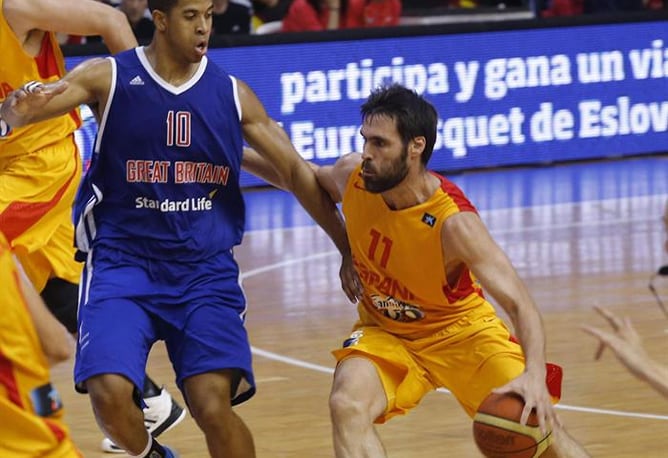 El alero de la selección española de baloncesto Fernando San Emeterio controla el balón junto a Myles Hesson, de la selección de Gran Bretaña, durante el partido de preparación para el europeo de septiembre que las dos selecciones han jugado en Murcia.