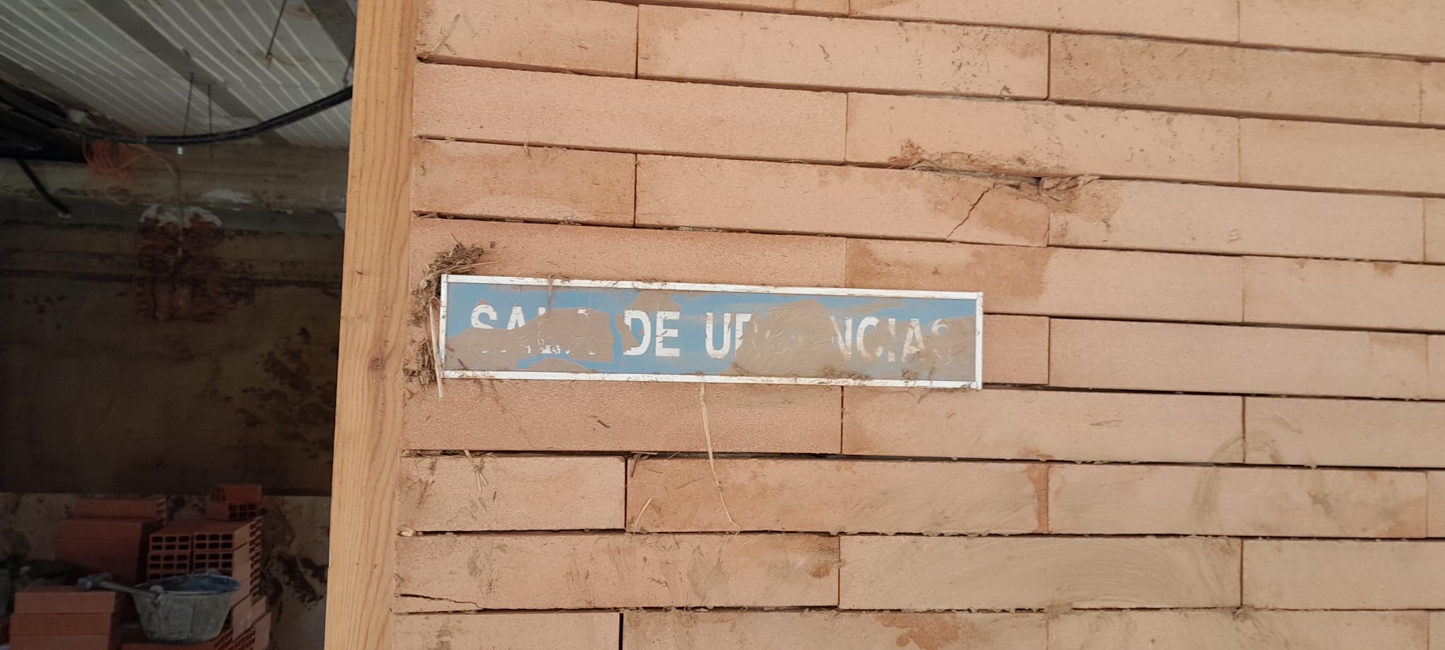 Cartel de la Sala de Urgencias del centro de Salud de Azuara lleno de barro.