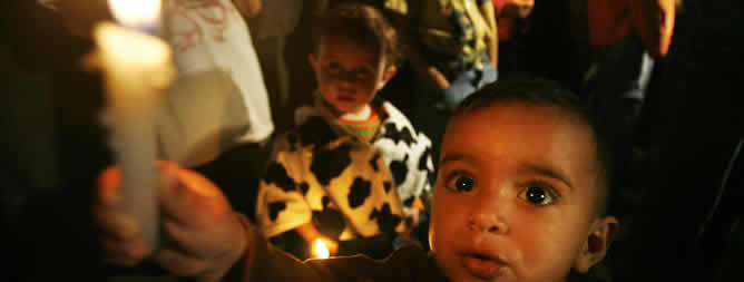 Un niño palestino sostiene una vela tras los cortes de luz en la ciudad de Gaza