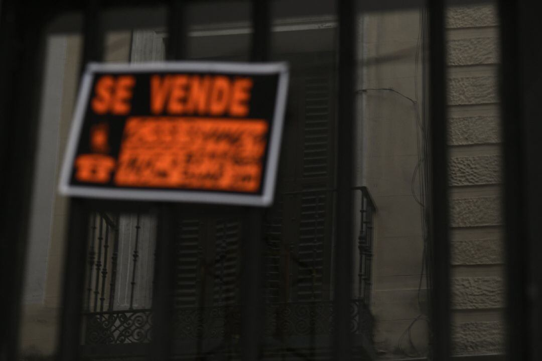 Cartel colgado en un edificio que indica que el inmueble está en venta