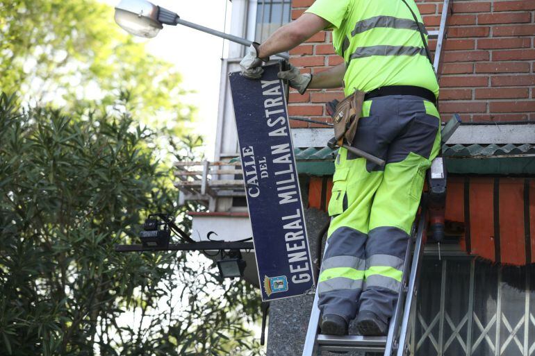 Un operario retira la placa de la antigua calle del General Millán Astray