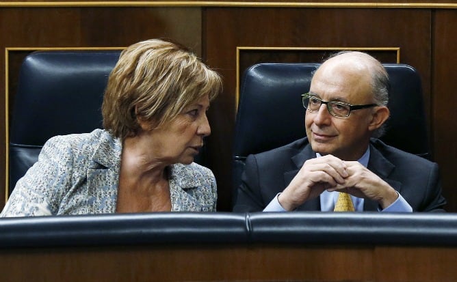 La vicepresidenta de la Cámara Baja, Celia Villalobos, conversa con el ministro de Haciensa, Cristóbal Montoro durante el pleno de este jueves en el Congreso de los Diputados.