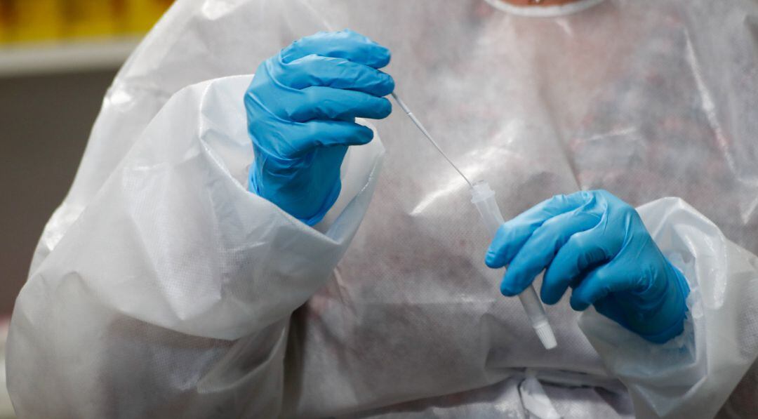 Imagen de archivo de una trabajadora sanitaria sostiene un test de antígenos