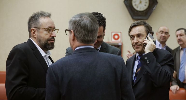 Los portavoces parlamentarios de Ciudadanos, Juan Carlos Girauta (i); del PP, Rafael Hernando (d), y el vicesecretario general de Ciudadanos, José Manuel Villegas (de espaldas), conversan tras haber sido aplazada la votación para elegir al exministro Jorg