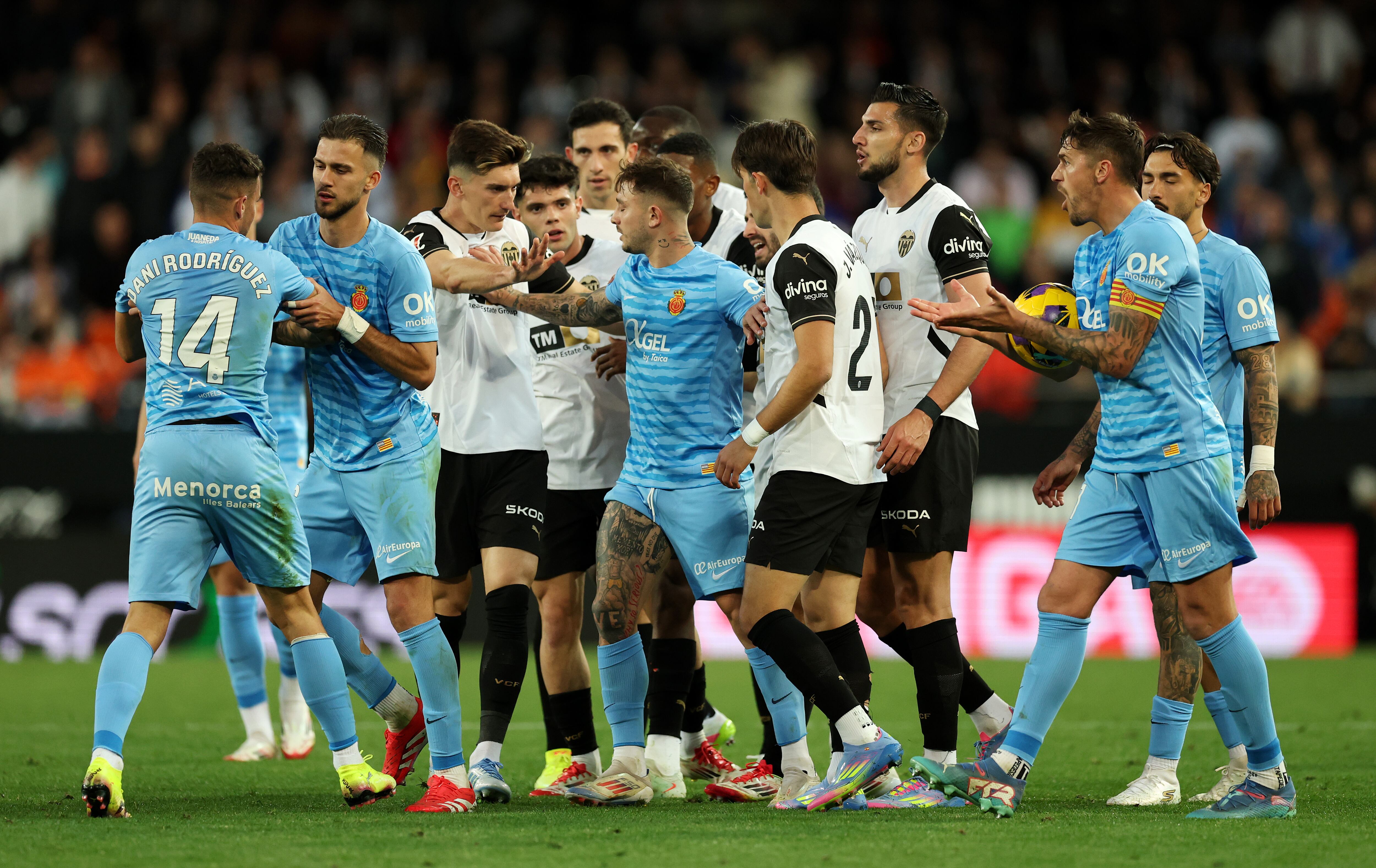 VALENCIA, SPAIN - MARCH 30: Dani Rodriguez of RCD Mallorca is held back by a teammate after clashing with players of Valencia CF during the LaLiga match between Valencia CF and RCD Mallorca at Estadio Mestalla on March 30, 2025 in Valencia, Spain. (Photo by Clive Brunskill/Getty Images)