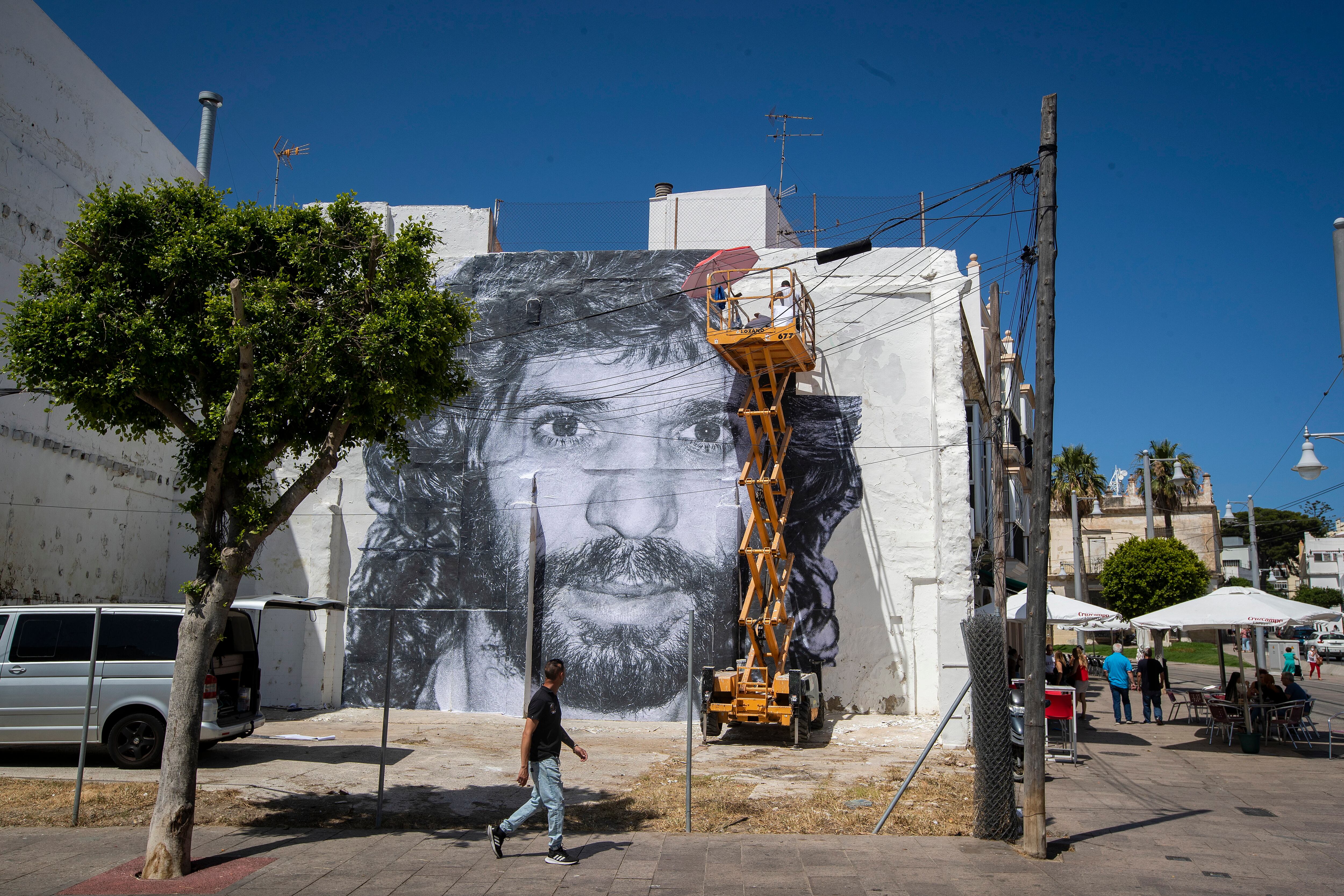 GRAFAND1278. SAN FERNANDO (CÁDIZ), 01/07/2022.- El fotógrafo jerezano Juan Carlos Toro se ha encargado de convertir una fotografía de José Monje Cruz, Camarón de la Isla, realizada por Joaquín Hernández, &quot;Kiki&quot;, tomada en 1991, poco antes de que el zarpazo del cáncer se asomara a su vida, en un mural gigante de diez por diez metros, desde la que el cantaor puede contemplar también el Centro de Interpretación Camarón de la Isla en San Fernando (Cádiz), cuando se cumplen treinta años de su muerte y sigue siendo una leyenda del flamenco. EFE/Román Ríos.
