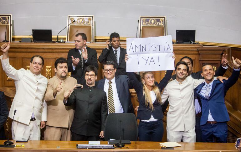 Lilian Tintori, esposa del líder opositor detenido Leopoldo López, acompañada de diputados de la Mesa de Unidad Democrática, sostiene un cartel pidiendo una amnistía durante la constitución de la Asamblea Nacional de Venezuela