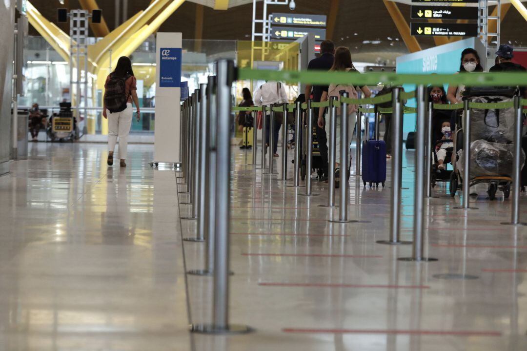 Pasajeros cerca de paneles informativos en la terminal T4 del aeropuerto Adolfo Suárez Madrid-Barajas, en Madrid