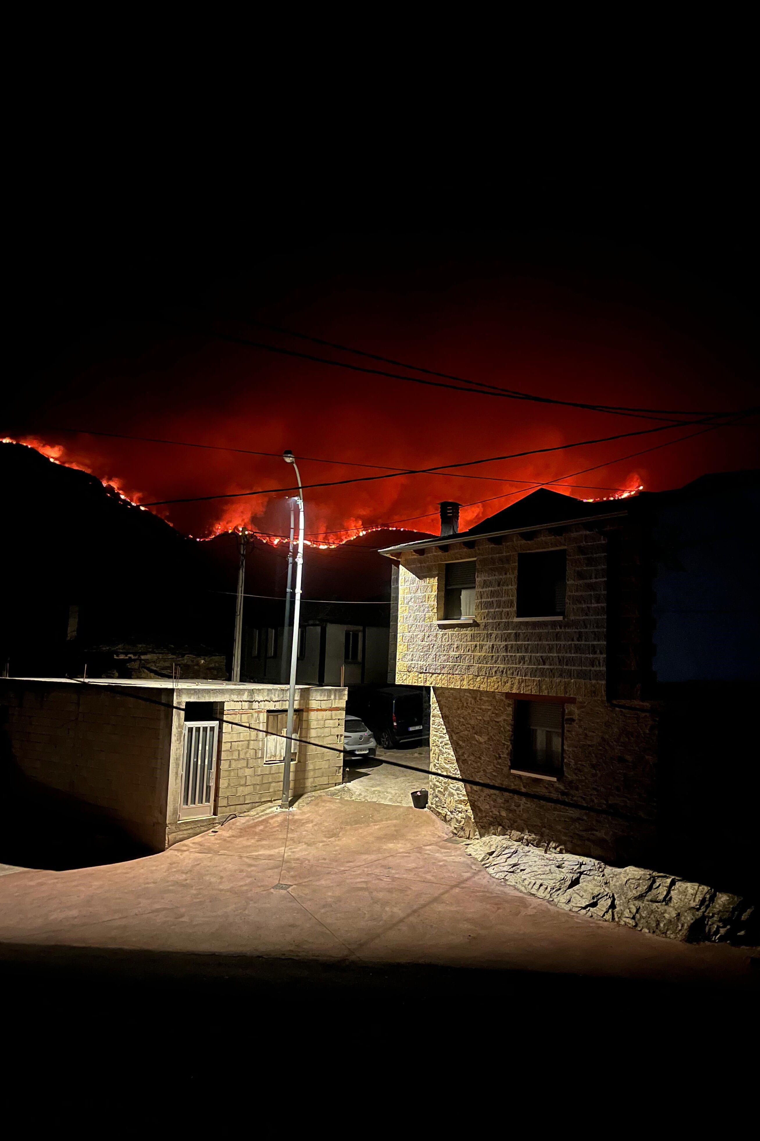 CASTRILLO DE CABRERA (LEÓN), 16/08/2025.- Las llamas se vislumbran desde Castrillo de Cabrera en el Bierzo, León, durante la madrugada de este sábado. EFE/ Ana F. Barredo
