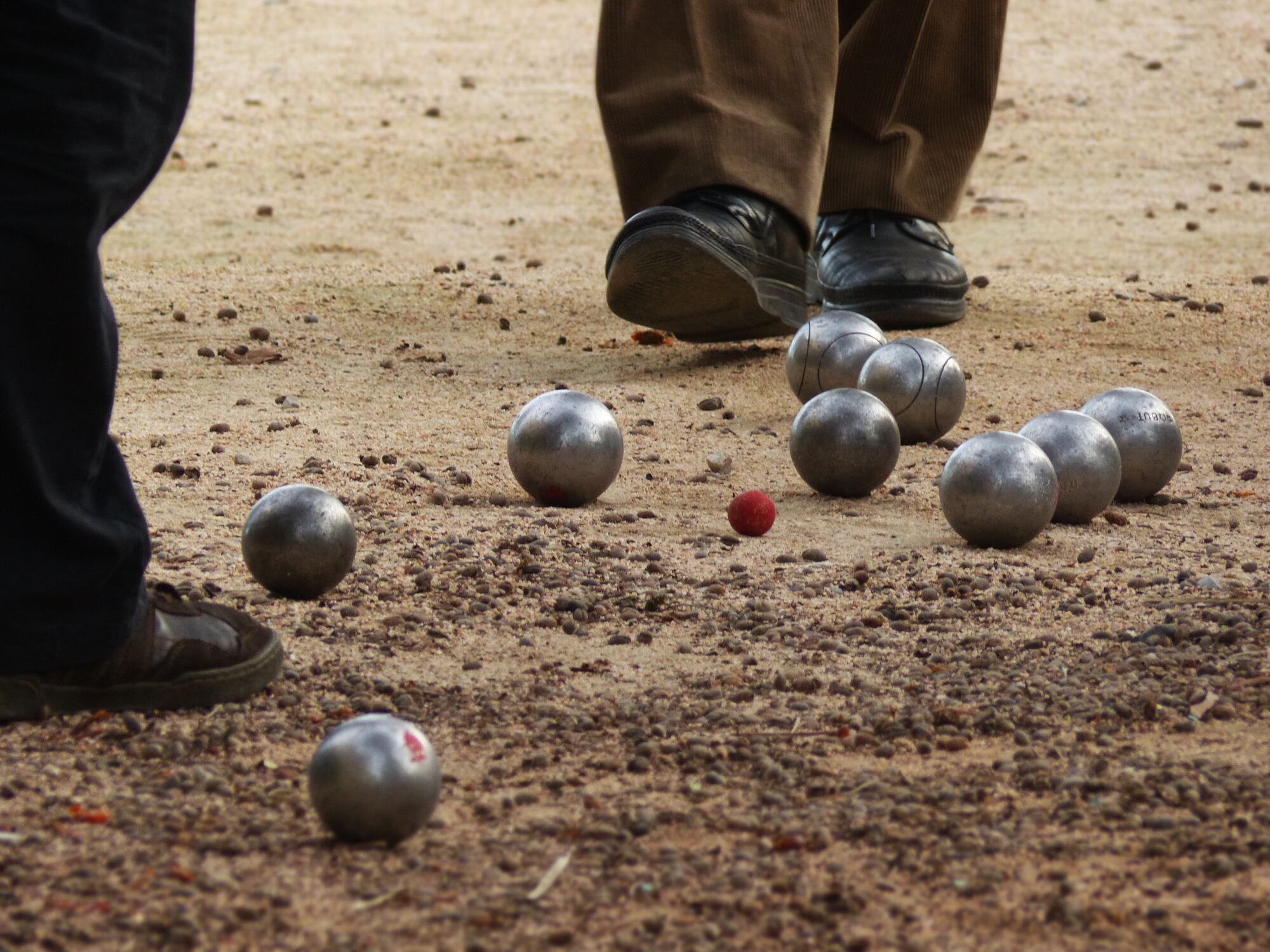Un grupo de personas juegan a la petanca.