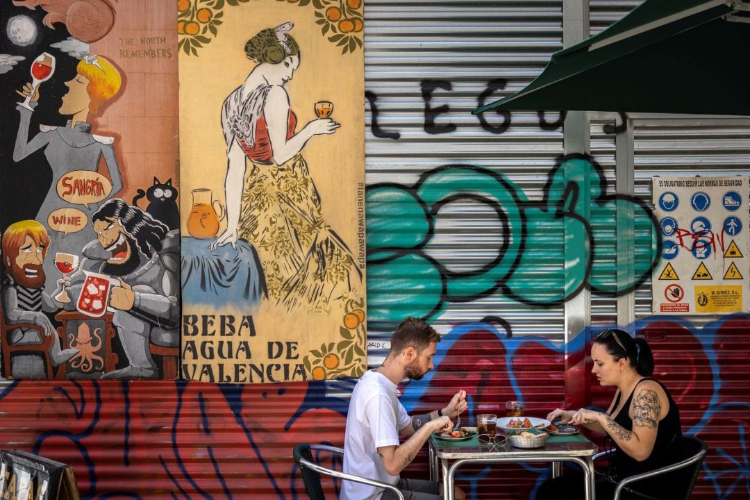  Dos personas comen en la terraza de un bar del centro histórico de València.