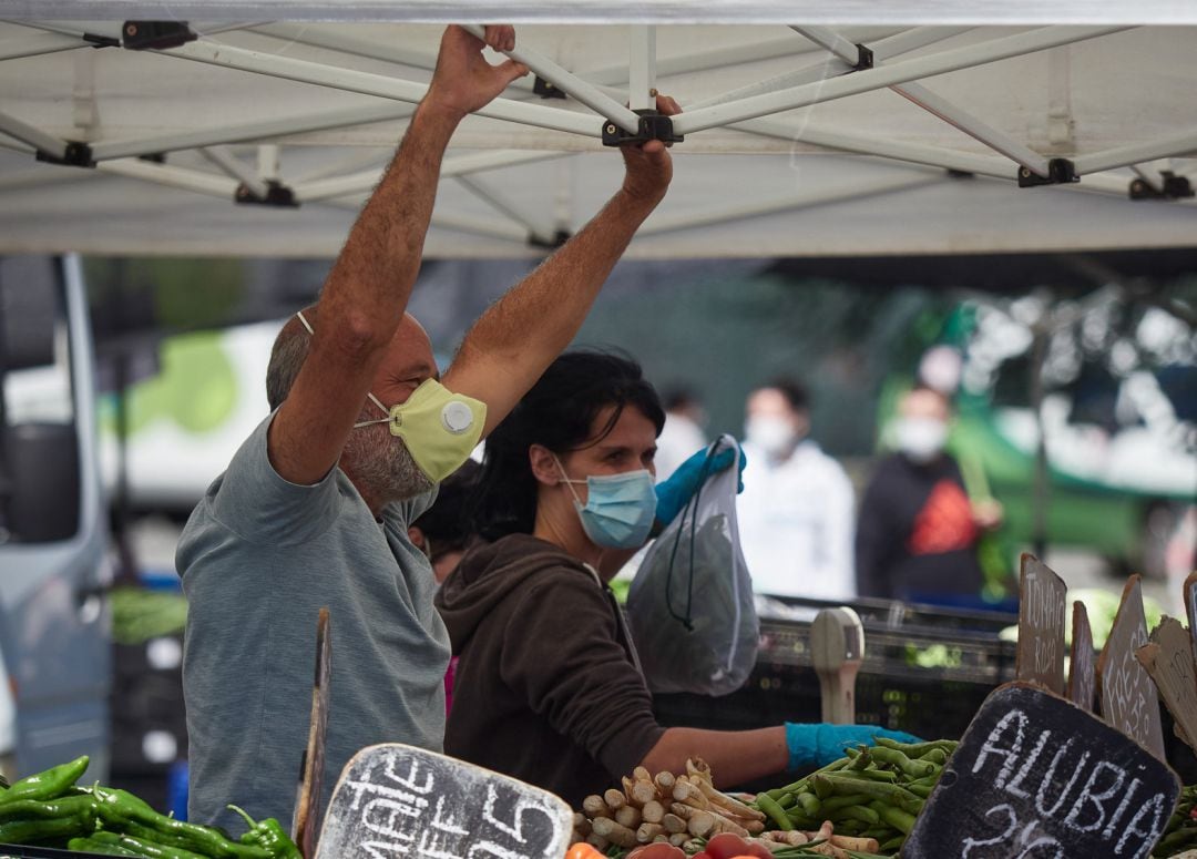 Un trabajador durante el primer dia de retorno de los puestos del mercadillo de Pamplona, donde Policia Municipal, SAR Navarra y Proteccion civil se han encargado de controlar el aforo, repartir mscarillas y ayudar a los dueños de los puestos a prepararse contra el covid19. 