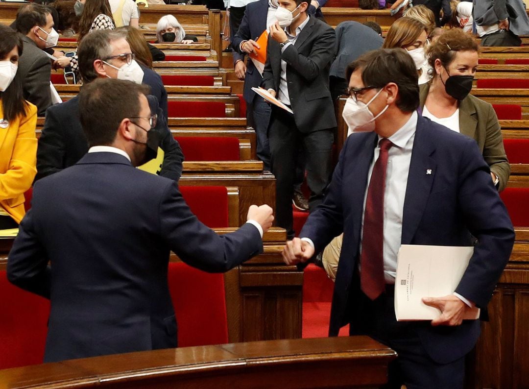 El candidato de ERC a la presidencia de la Generalitat, Pere Aragonès (i) saluda al líder del PSC Salvador Illa durante la primera jornada del debate de su investidura, esta tarde en el Parlamento de Cataluña.