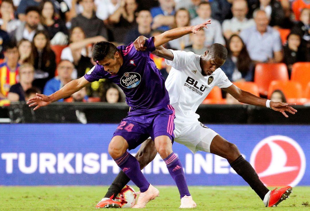 El centrocampista francés del Valencia, Geoffrey Kondogbia (d), disputa el balón ante el defensa argentino del Celta, Facundo Roncaglia, durante el encuentro correspondiente a la sexta jornada disputado esta noche en el estadio valencianista de Mestalla. 