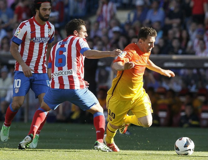 Messi pelea un balón con Koke y Arda en el Calderón