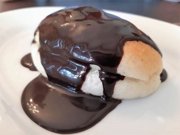 Carmelita rellena de crema y bañada en chocolate caliente