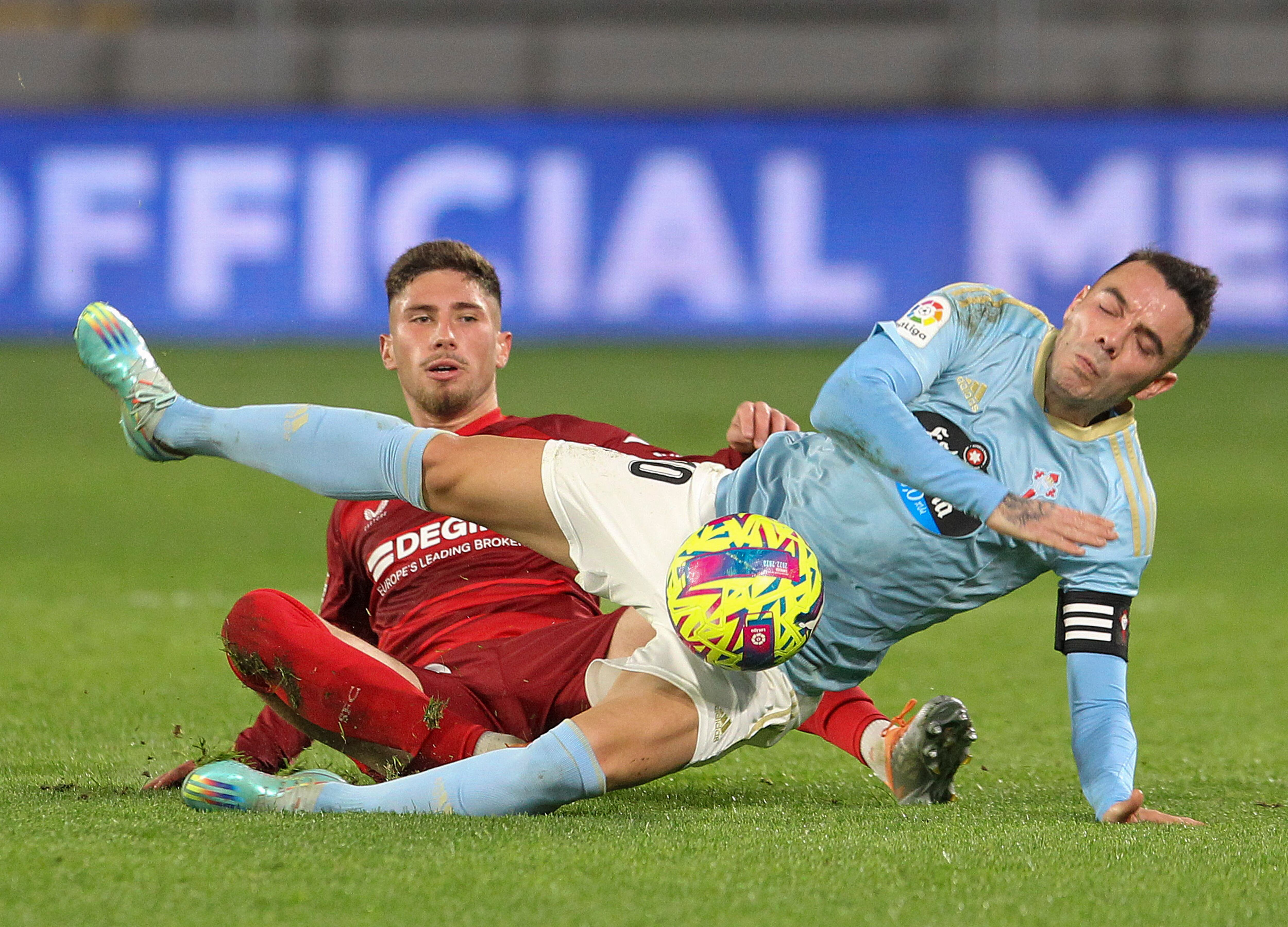 VIGO (PONTEVEDRA), 30/12/2022.- El delantero del Celta Iago Aspas (d) pelea un balón con Jose Angel Carmona, del Sevilla durante el partido de Liga en Primera División que disputan este viernes en el estadio de Balaídos, en Vigo. EFE/Salvador Sas
