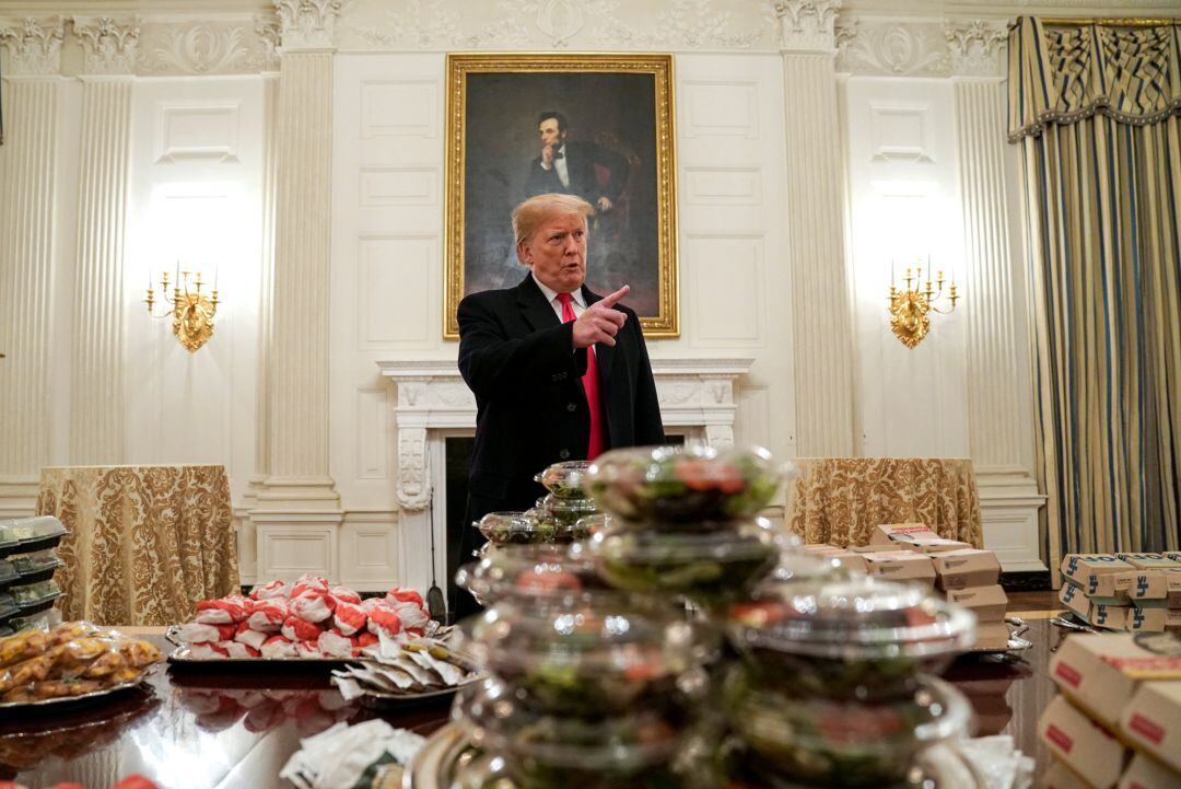 Donald Trump, hablando en un salón de la Casa Blanca frente a la comida rápida con la qu eha recibido a los miembros del equipo ganador del campeonato universitario de fútbo americano.