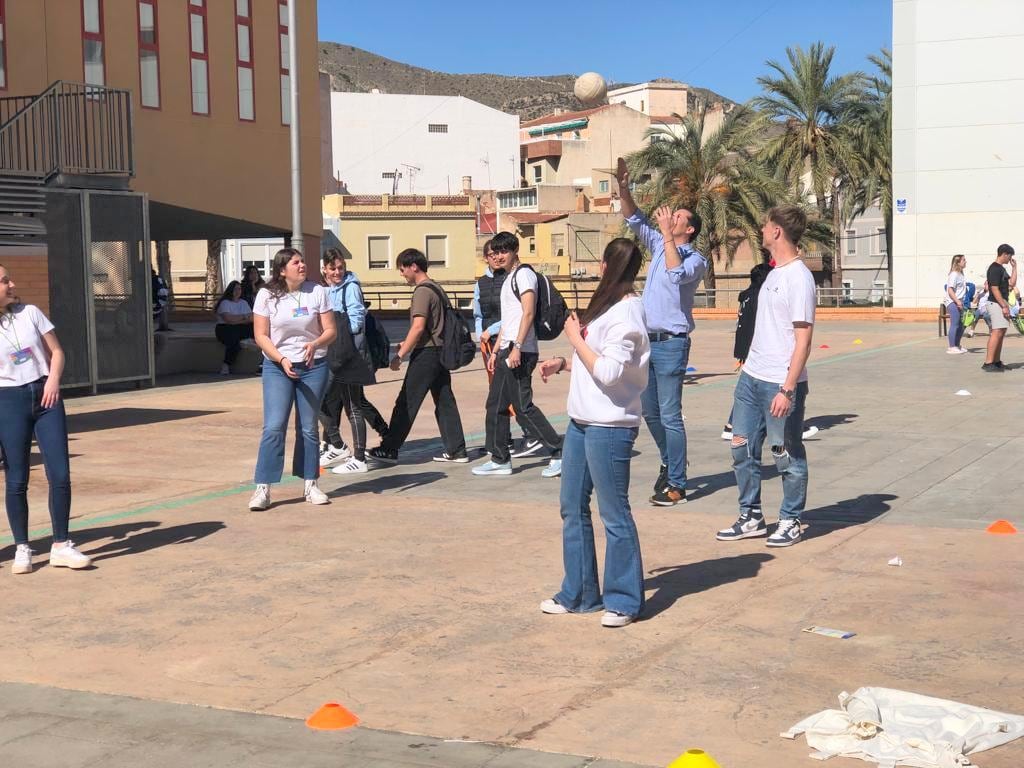 Alfaro jugando al vóleibol con un grupo de alumnos