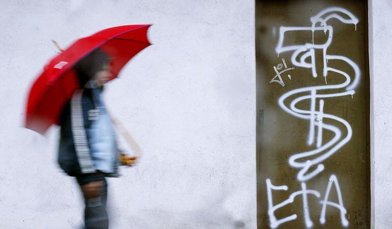 Un joven pasea junto a un grafiti de ETA en Guernica