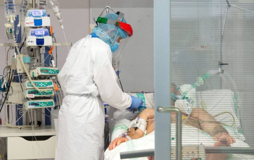 Un sanitario atiende a un hombre afectado por COVID en una imagen de archivo