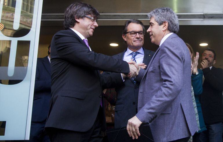  El exconseller de Presidencia y diputado de Democràcia i Llibertat (DiL) Francesc Homs (d), saluda al presidente del Govern catalán, Carles Puigdemont (i), y el expresidente Artur Mas, a su llegada a la sede de CDC tras declarar de forma voluntaria ante 