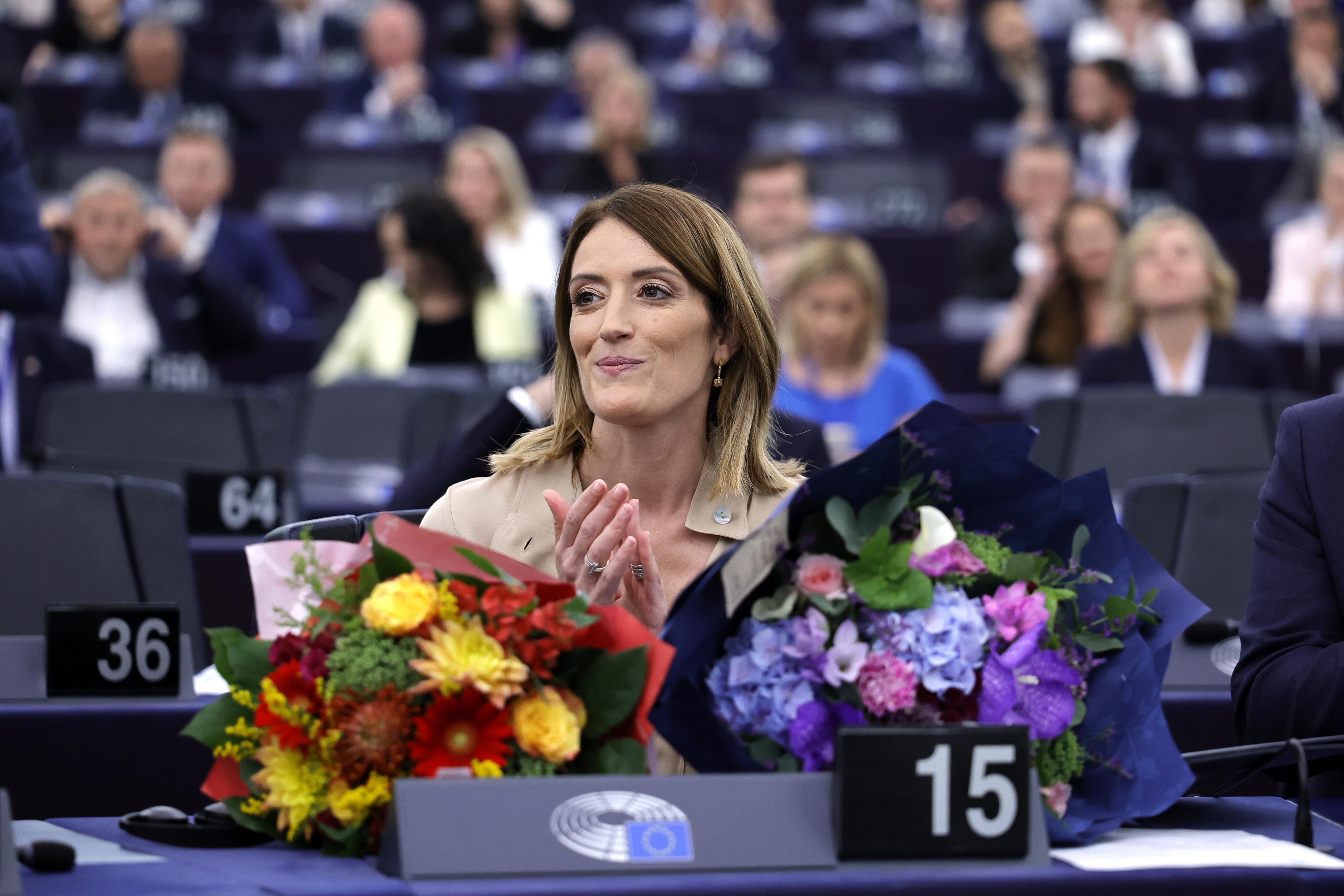 Roberta Metsola posa junto a ramos de flores después de haber sido reelegida presidenta del Parlamento Europeo.