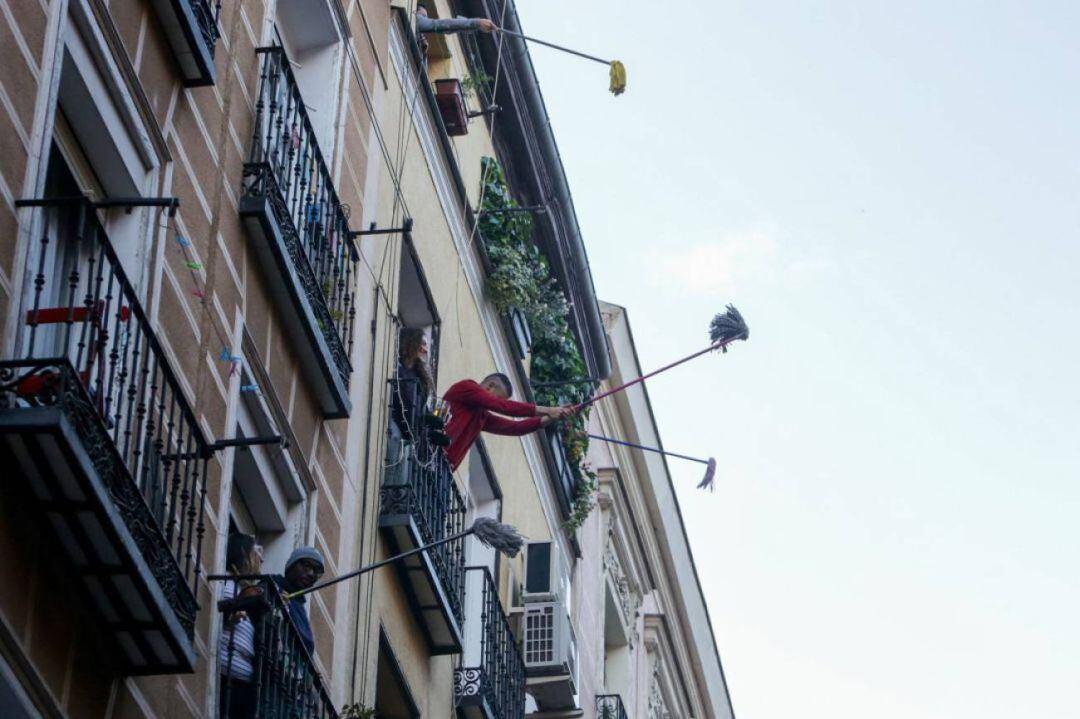Vecinos del barrio madrileño de Lavapiés, realizan la 'Fregonada de Lavapiés', un gesto que consiste en agitar fregonas desde sus balcones para "limpiar el virus" cada día después del aplauso habitual a las 20h