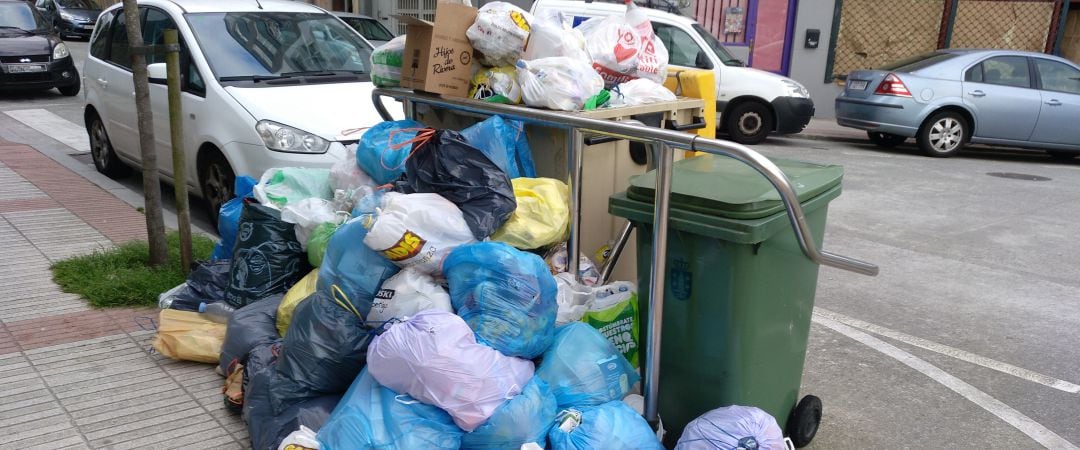 Basura acumulada alrededor de un contenedor