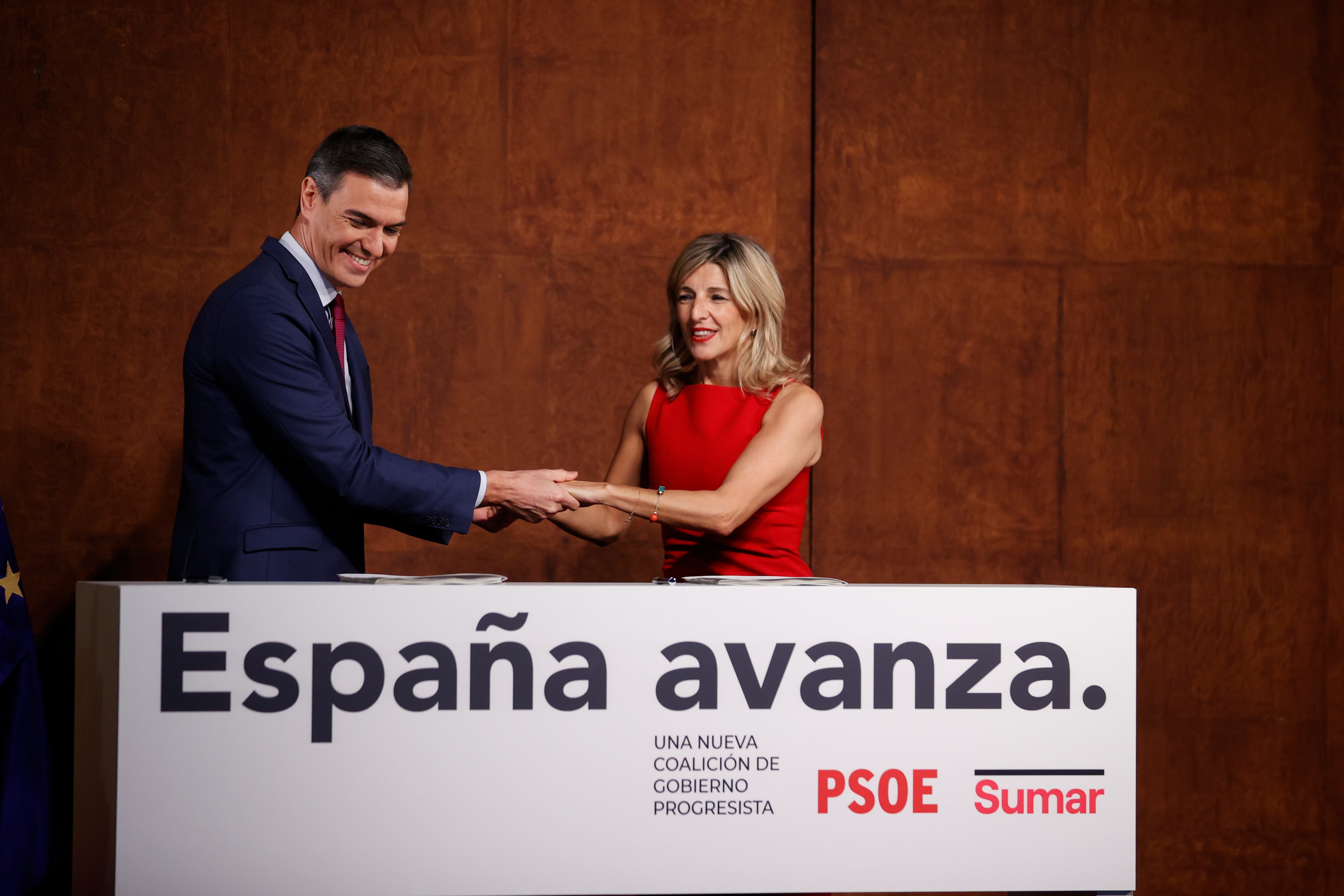 La líder de Sumar, Yolanda Díaz (d), y el presidente del Gobierno, Pedro Sánchez (i), tras firmar el acuerdo para formar Gobierno