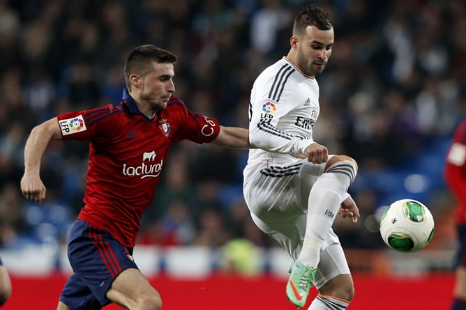 El jugador del Real Madrid Jesé (d) controla un balón ante Oriol Riera, de Osasuna