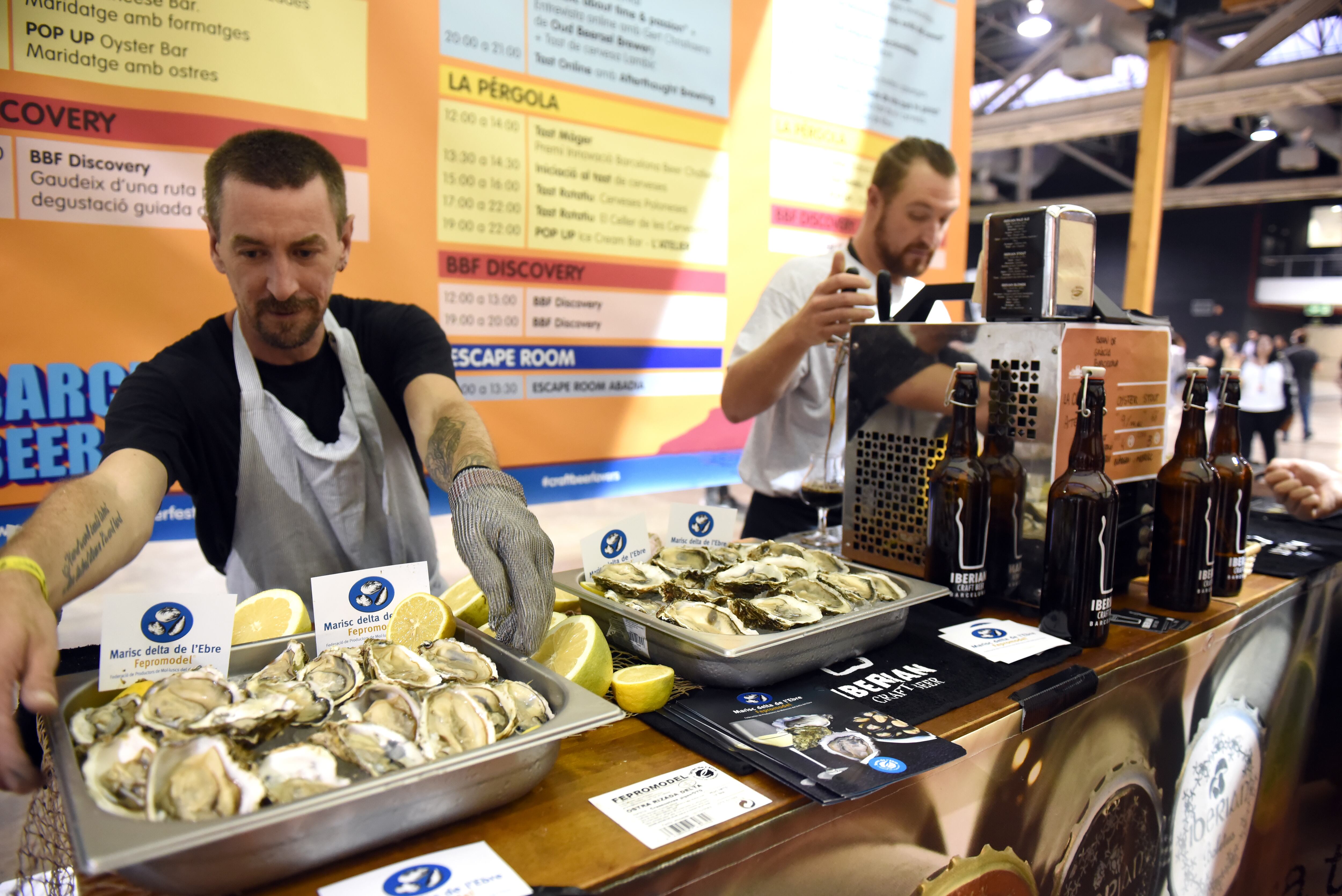 Dos hombres sirven ostras con cerveza en el Barcelona Beer Festival