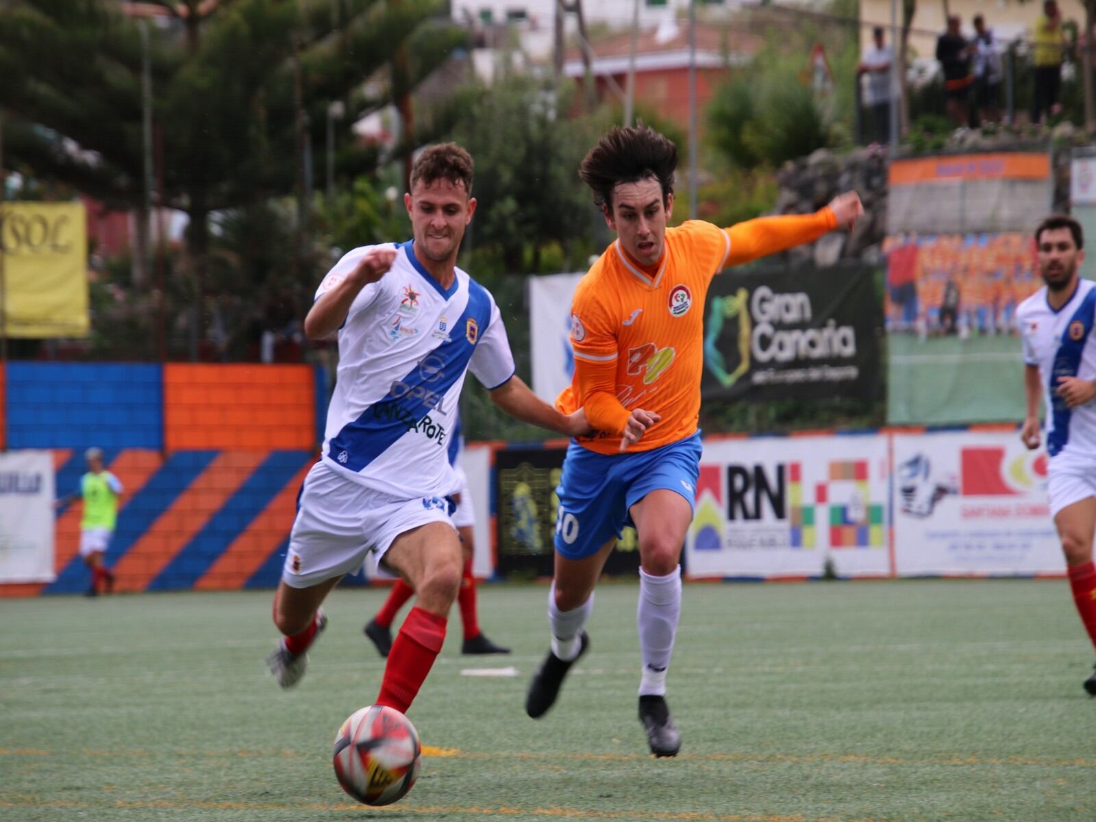 Disputa del balón entre jugadores de la UD Lanzarote y el Panadería Pulido San Mateo.