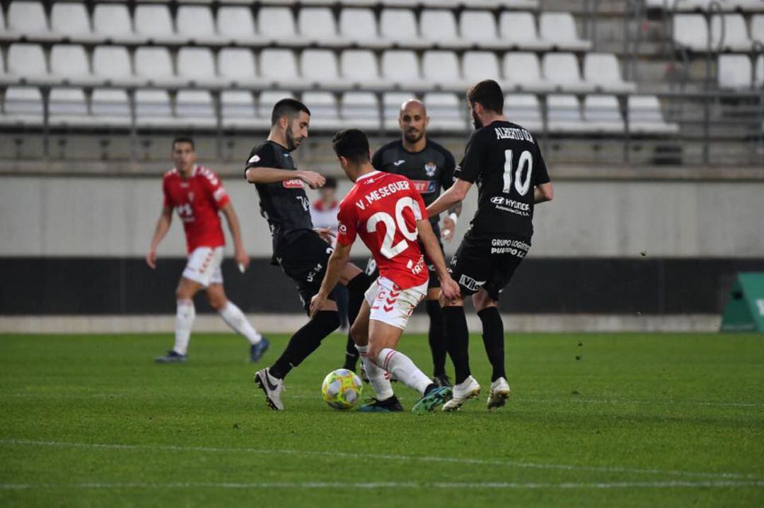 Víctor Meseguer intenta salvar un balón ante dos jugadores del Talavera de la Reina