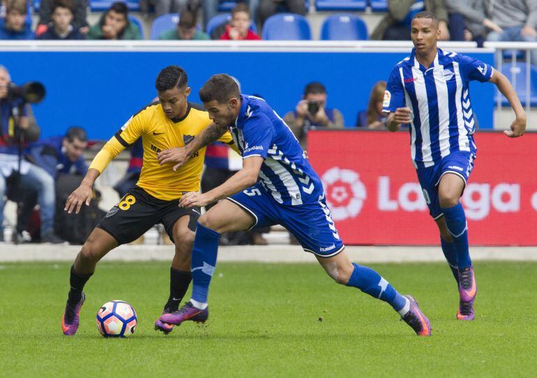 El delantero serbio del Deportivo Alavés, Aleksandar Katai, disputa el balón con el centrocampista venezolano del Malaga Roberto Rosales.