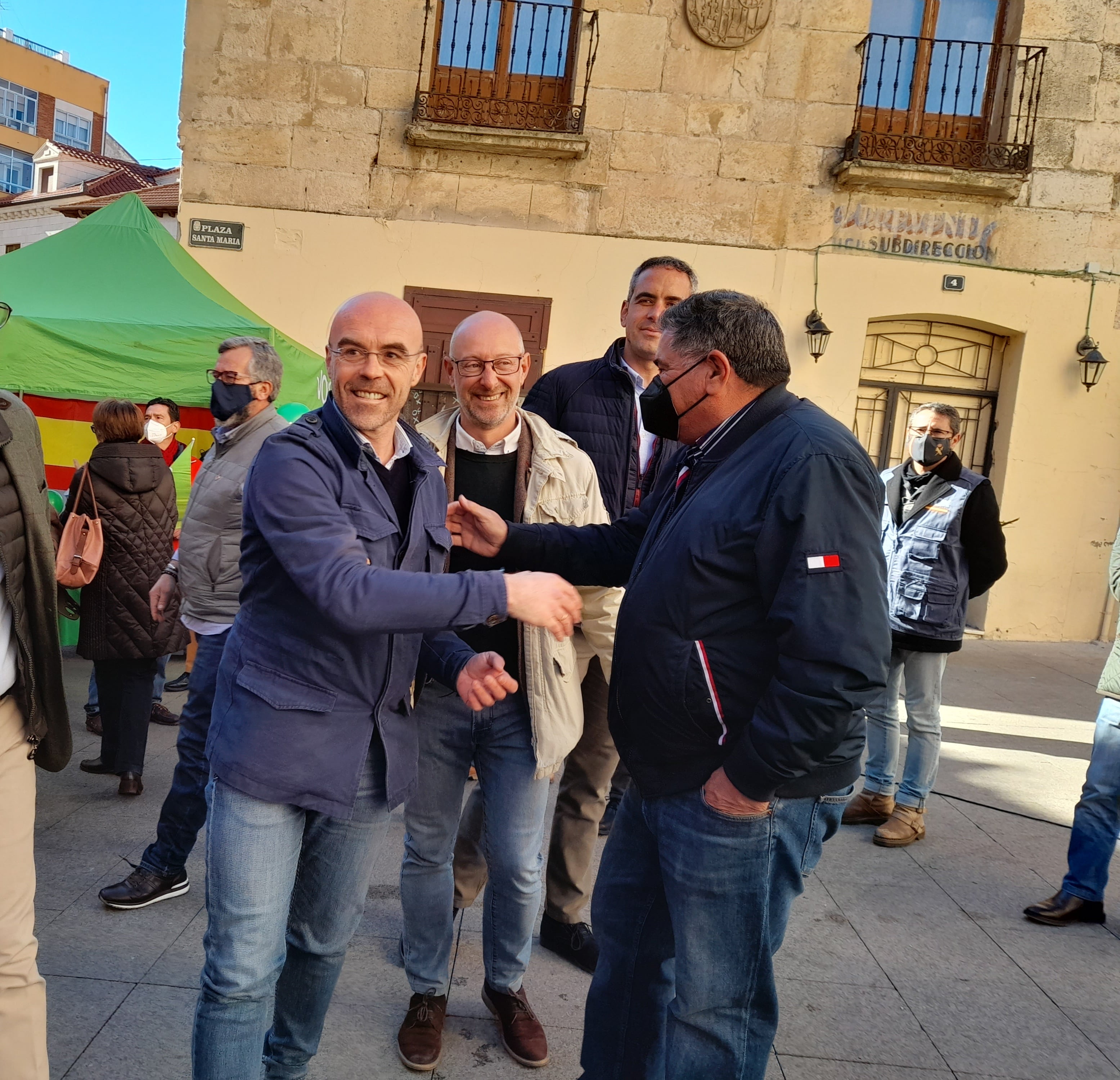 Jorge Buxadé saluda a un simpatizante en presencia de Iñaki Sicilia y Sergio Chagartegui antes de comenzar el acto electoral de Vox en Aranda