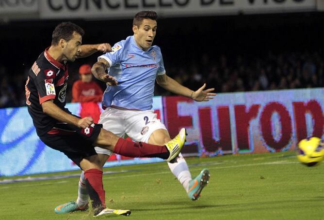 El defensa del Celta Hugo Mallo (d) lucha la pelota con el centrocampista portugués del Deportivo Bruno Gama (i), durante el partido correspondiente a la novena jornada de la Liga de Primera División