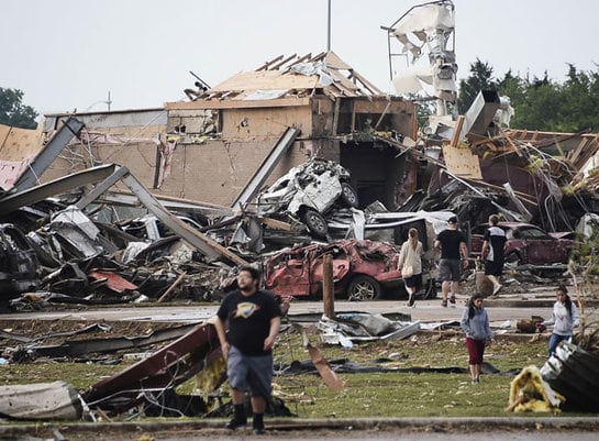 Los vecinos caminan entre los edificios y vehículos destruidos tras el tornado que azotó Moore