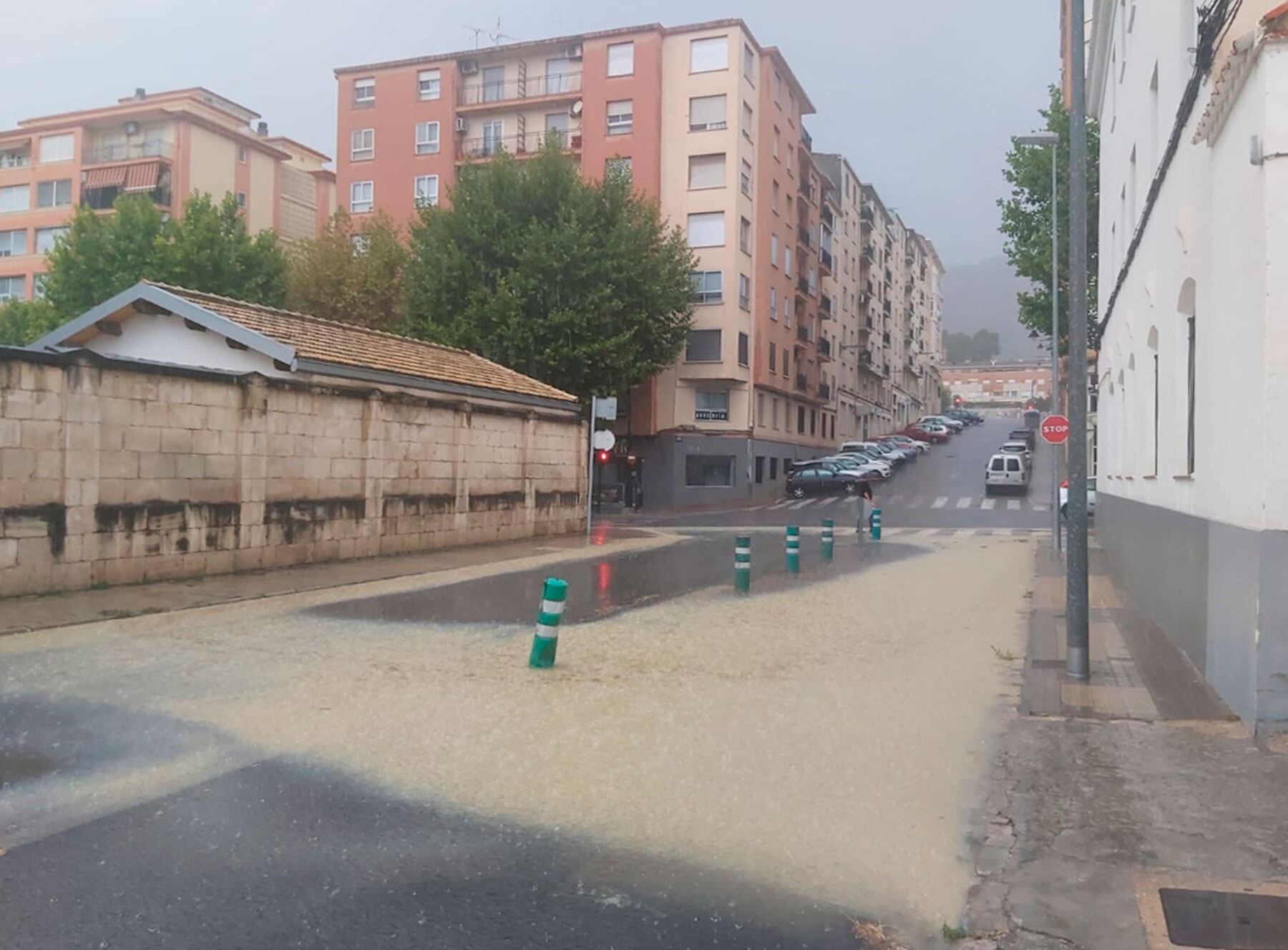 Imagen de la lluvia caída este mediodía con un charco de grandes dimensiones en la calle Escorxador