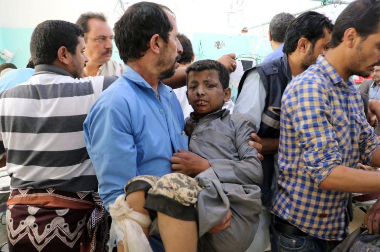 Un hombre sostiene a un niño herido por el ataque en Yemen