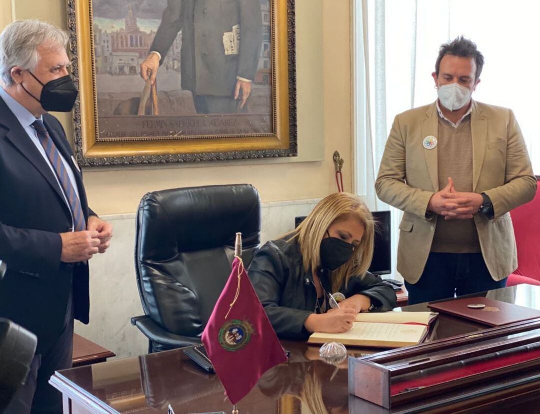 La alcaldesa de Jerez Mamen Sánchez firmando en el libro de honor del Ayuntamiento de Cádiz en presencia de su regidor José María González