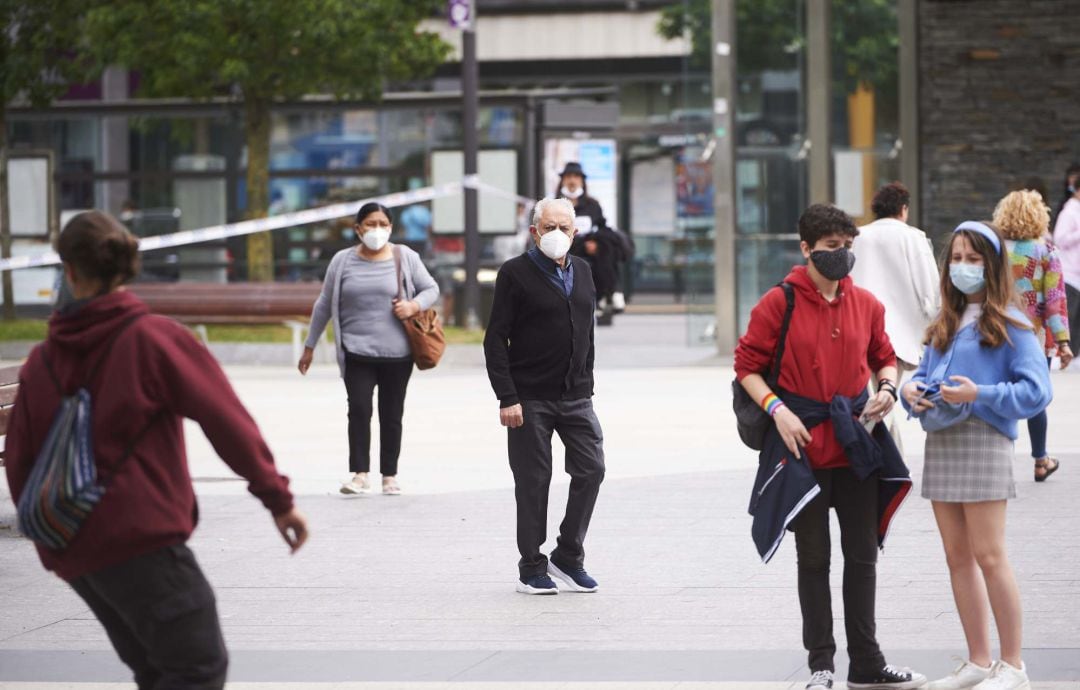 Transeúntes pasean por calles de Santander con mascarilla.