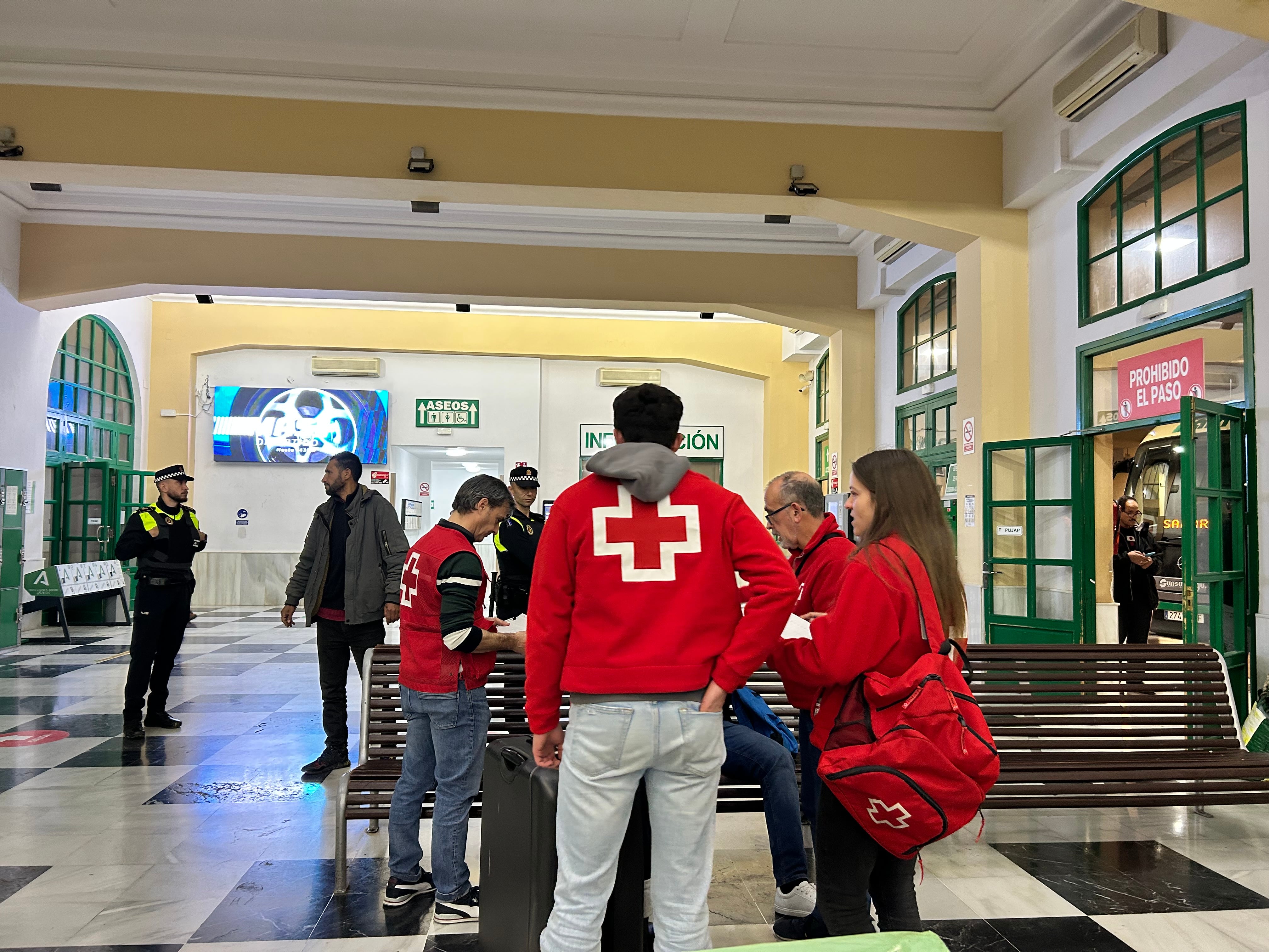 Voluntarios de Cruz Roja atienden a varios temporeros en la Estación de autobuses de Jaén.