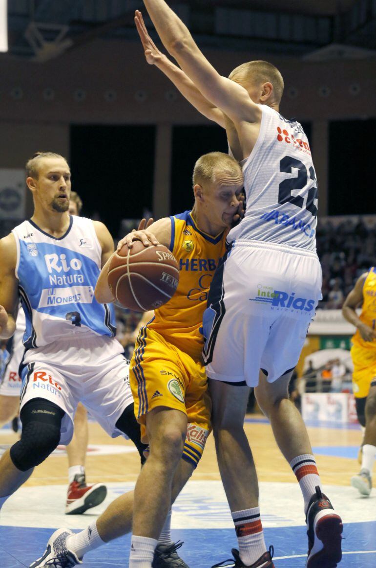 El alero lituano del Rio Natura Monbus Obradoiro Eimantas Bendzius (d) defiende la entrada del escolta Sasu Salin, del Herbalife, durante el partido de la octava jornada de la liga Endesa, en el pabellón multiúsos de Sar, en Santiago de Compostela.