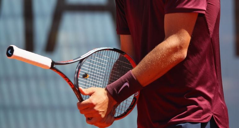 Bernard Tomic intenta golpear la pelota con el mango de la raqueta