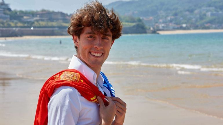 Odriozola posa con la camiseta de la selección y de la Real en la playa de La Concha