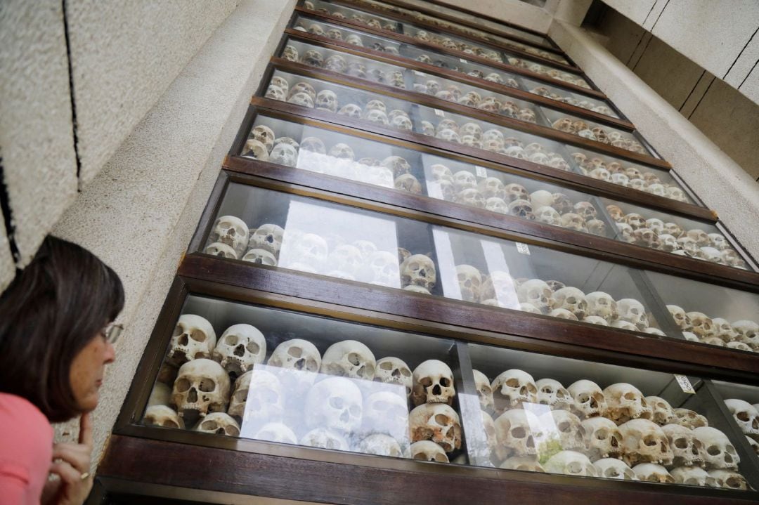 Una turista observa las calaveras de varias víctimas fallecidas bajo el régimen de los jemeres rojos expuestos en el Centro del Genocidio Choeung Ek, a las afueras d ePhnom Penh (Camboya).