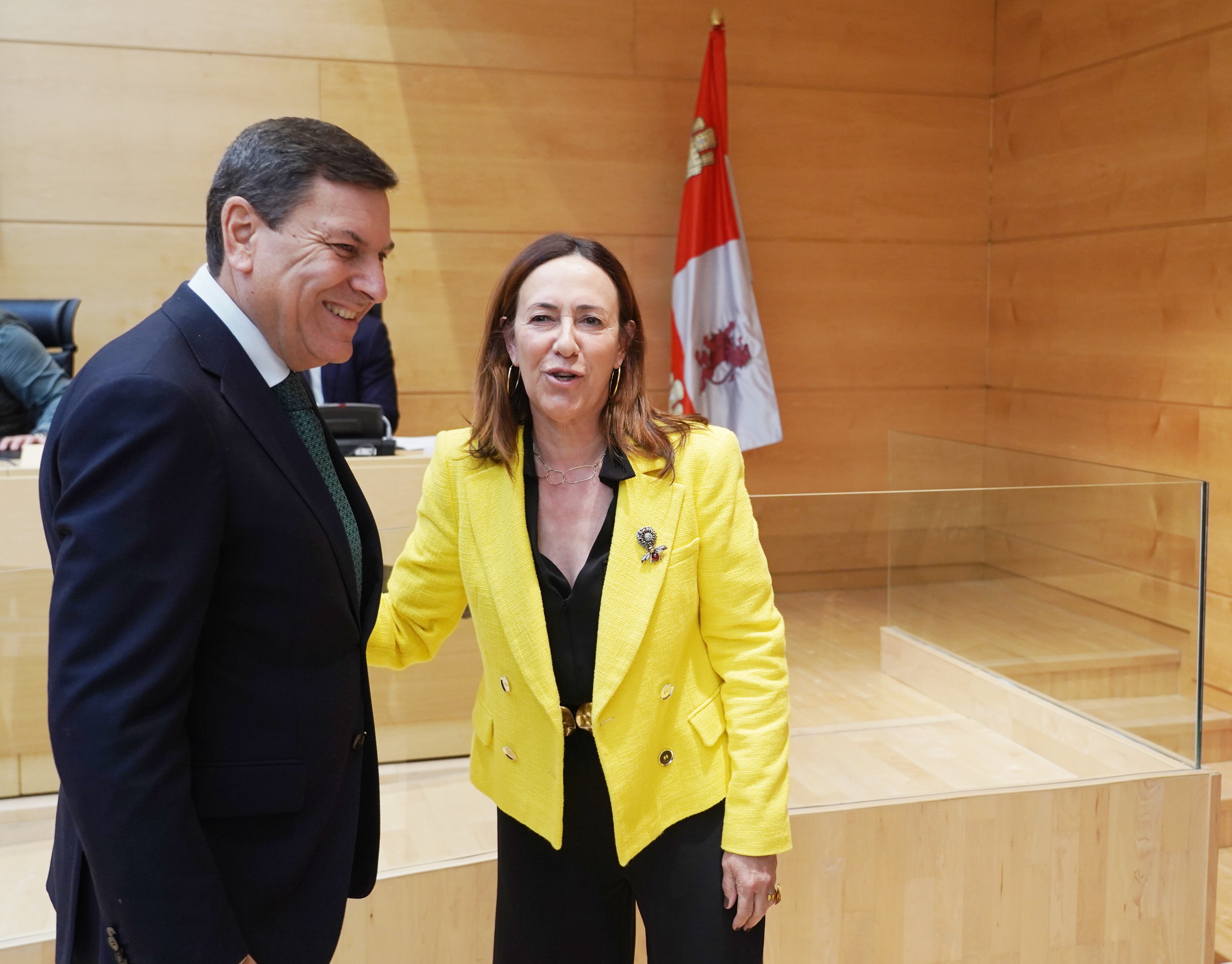 El consejero de Economía y Hacienda, Carlos Fernández Carriedo, saluda a la procuradora del PSOE, Rosa Rubio, antes de su comparecencia en las Cortes para informar sobre el proyecto de ley de Presupuestos Generales de la Comunidad para 2026